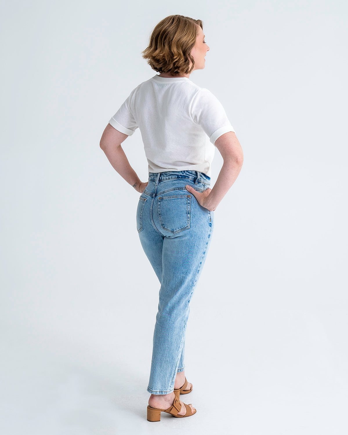 Full length, back view of pear shaped jeans in washed blue colour. Model wears size 8 in average length.