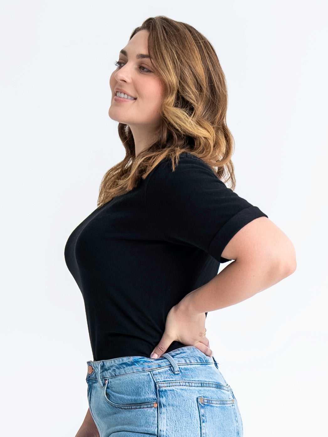 Side view of black t-shirt made for big boobs. Model wears size 12.